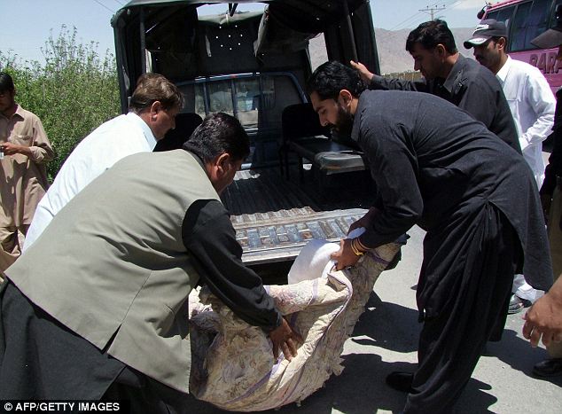 Tragic: Pakistani police officials carry the covered dead body of British aid worker Khalil Rasjed Dale, found along a street in Quetta 